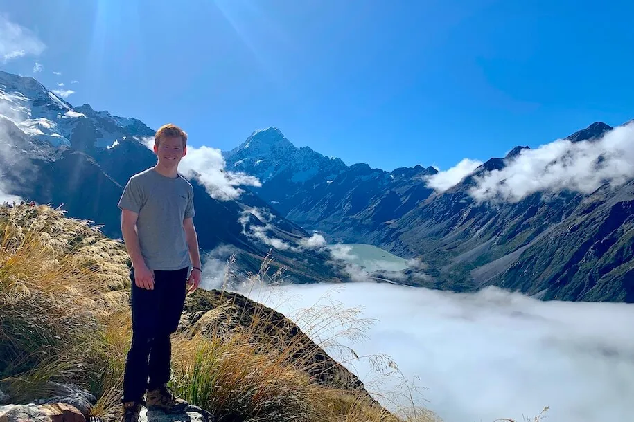 Leggatt Kerek '24 in New Zealand surrounded by majestic mountains on a beautiful sunny day.