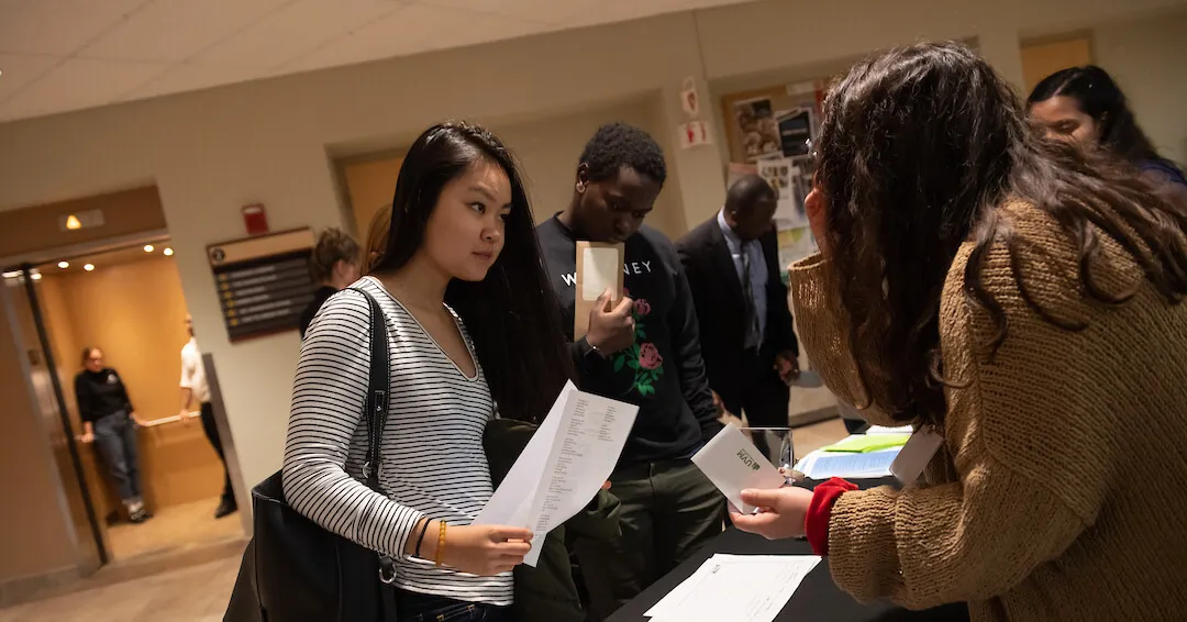 Student putting down there resume at an event