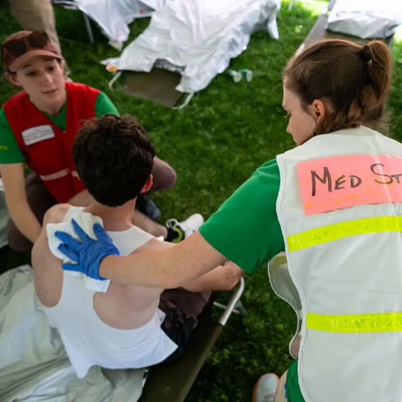 Larner students tend an injured runner in medical tent