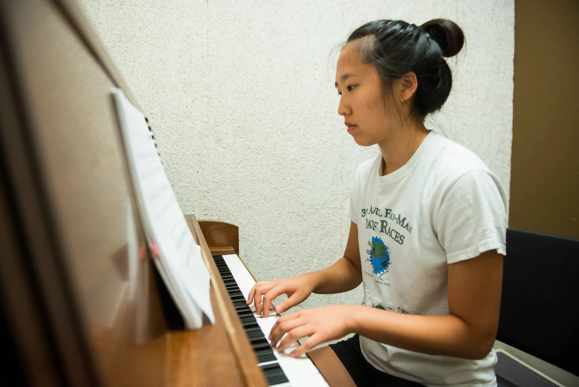 Student playing a piano.