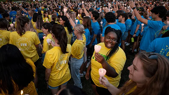 A large group of students gather on the UVM green
