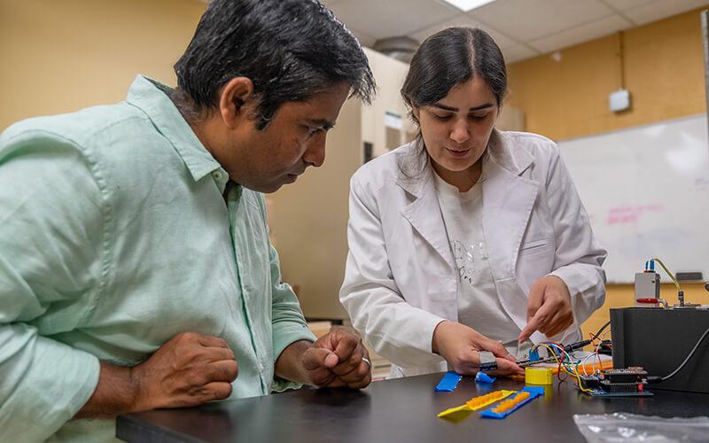 Professor and post-doctoral student collaborating in the lab