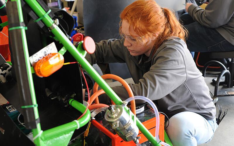 A CEMS student at work on the AERO club's race car