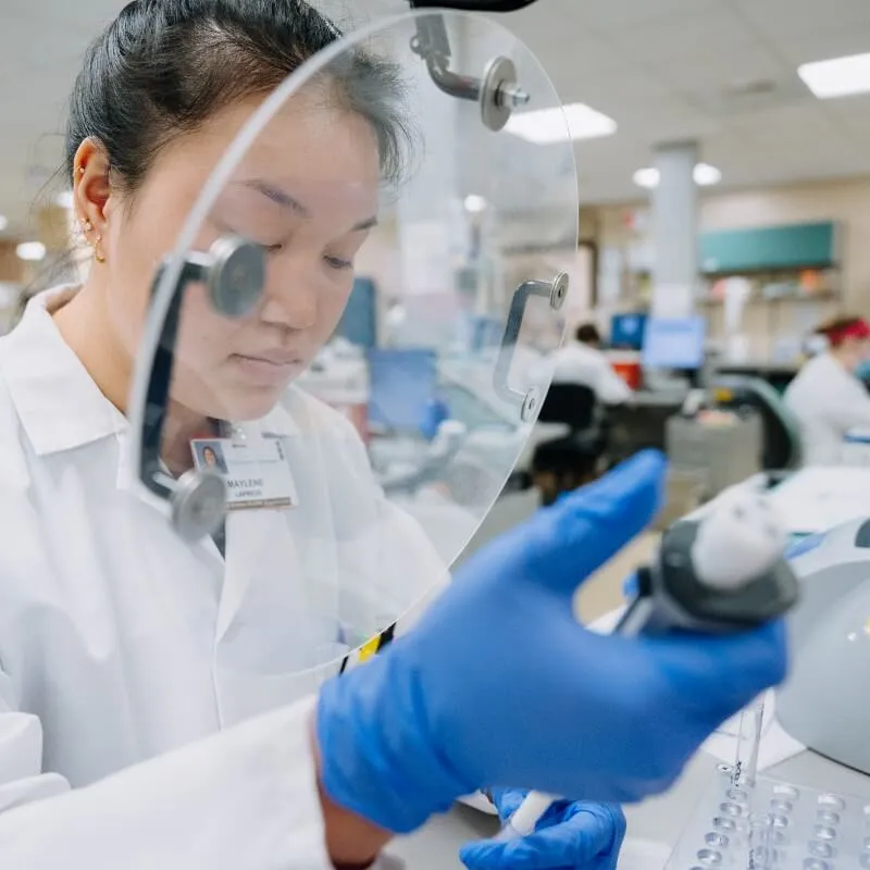 A medical laboratory scientist observes a sample in the lab