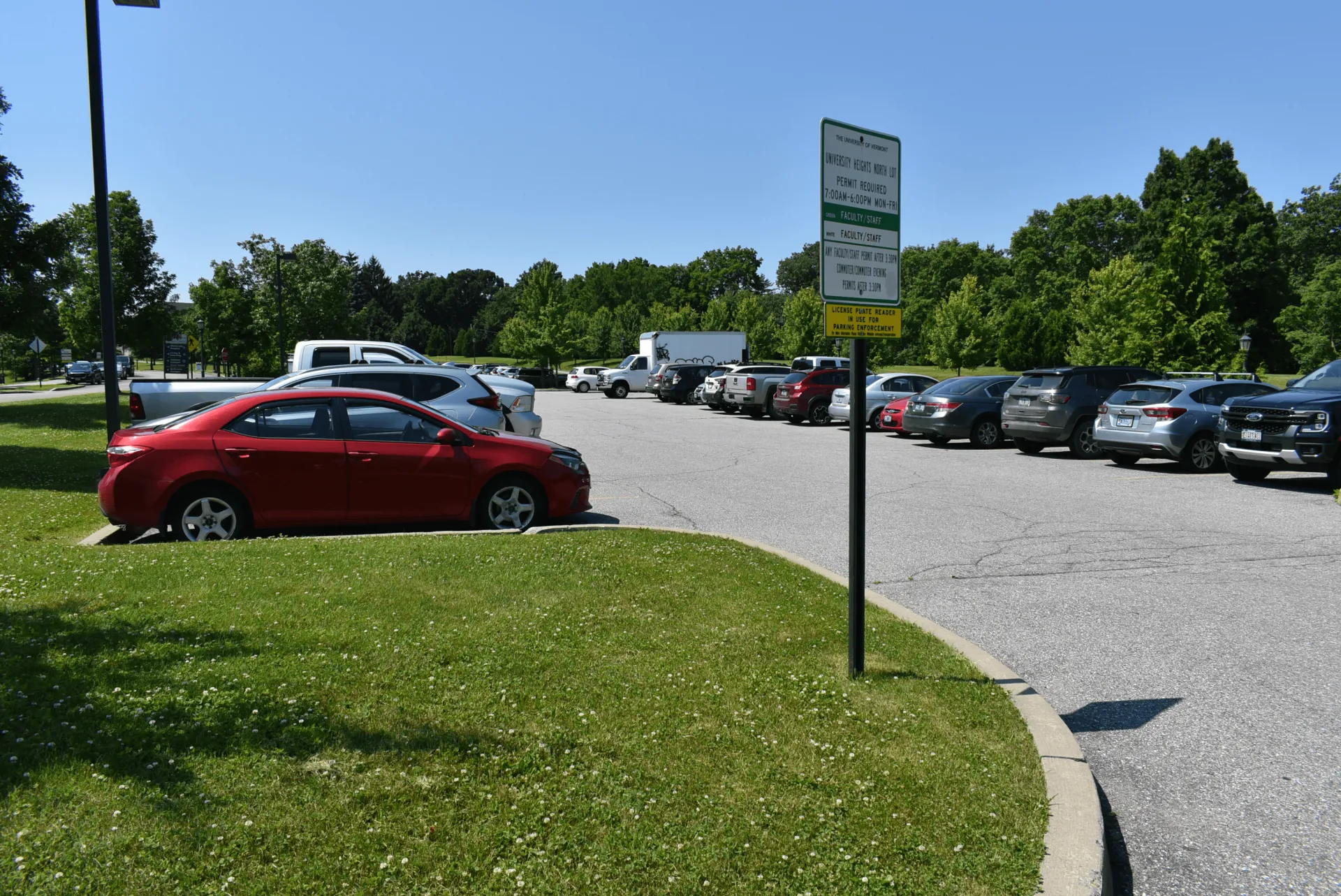 cars parked in a lot with a parking sign on the UVM campus