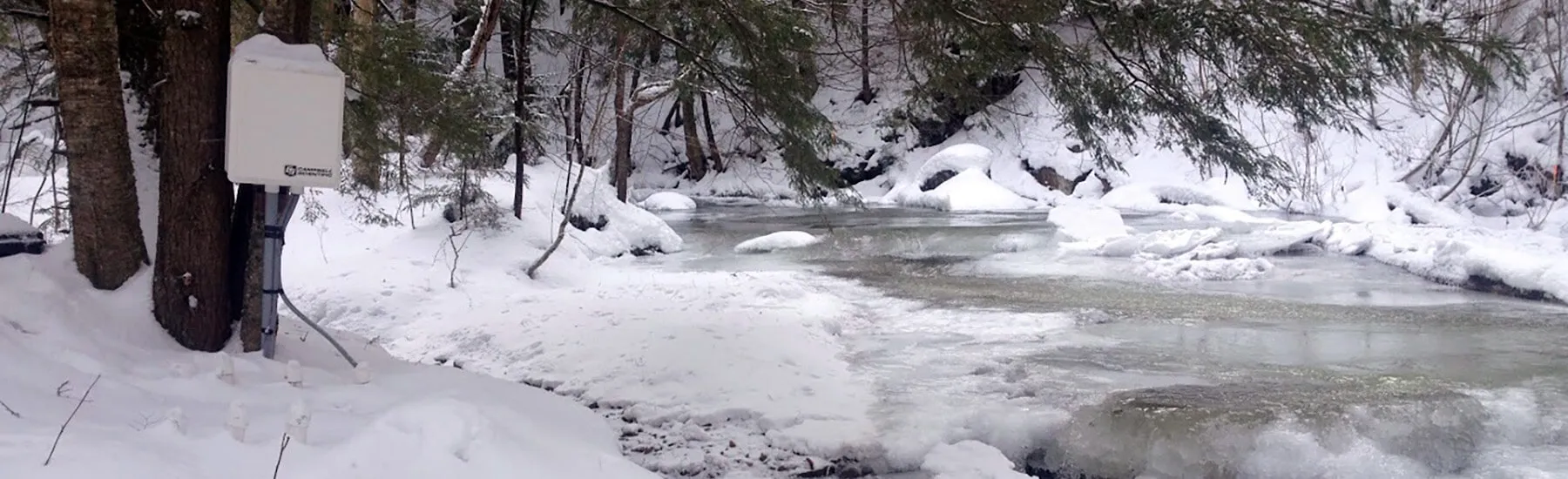 Gently flowing stream, surrounded by a serene winter landscape