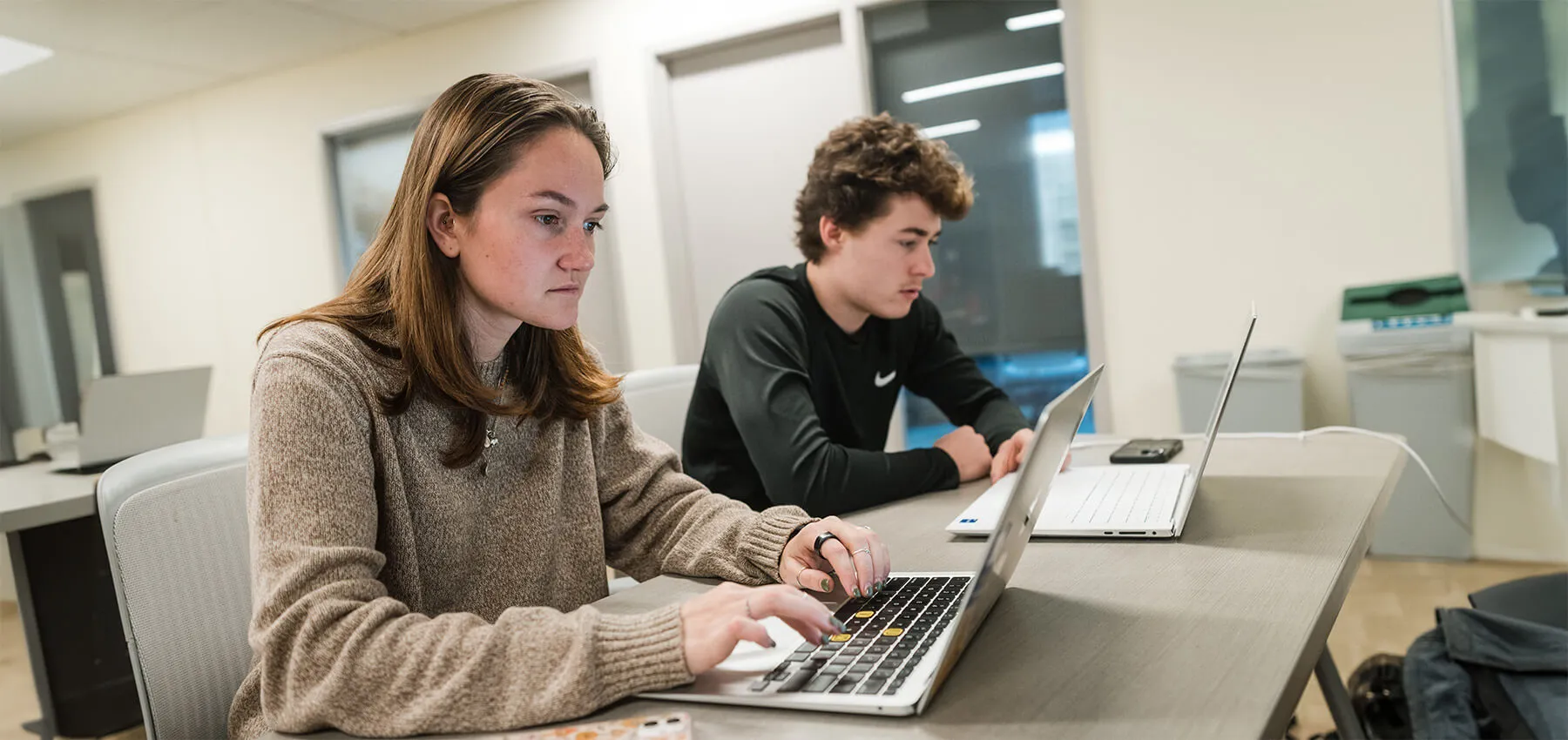 Two CEMS students at work on their laptops
