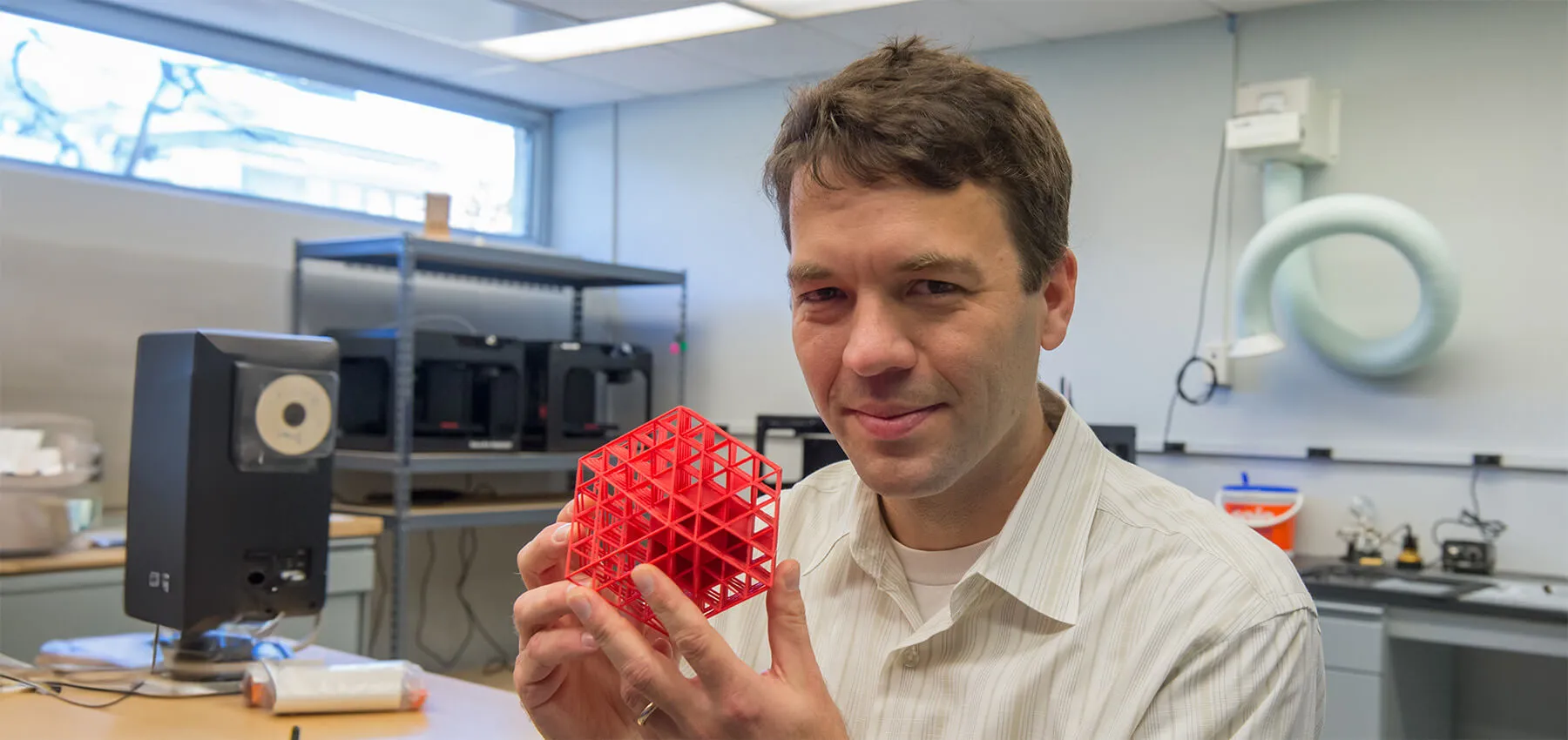 Professor Greg Warrington holding a 3D printed latticed cube
