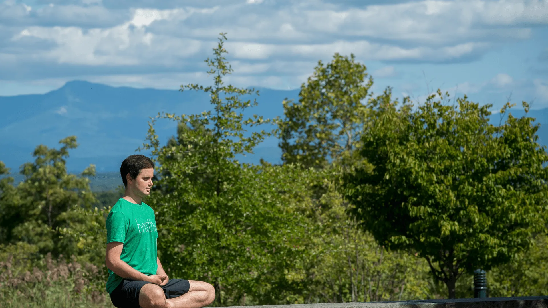 person meditating with mountain in background