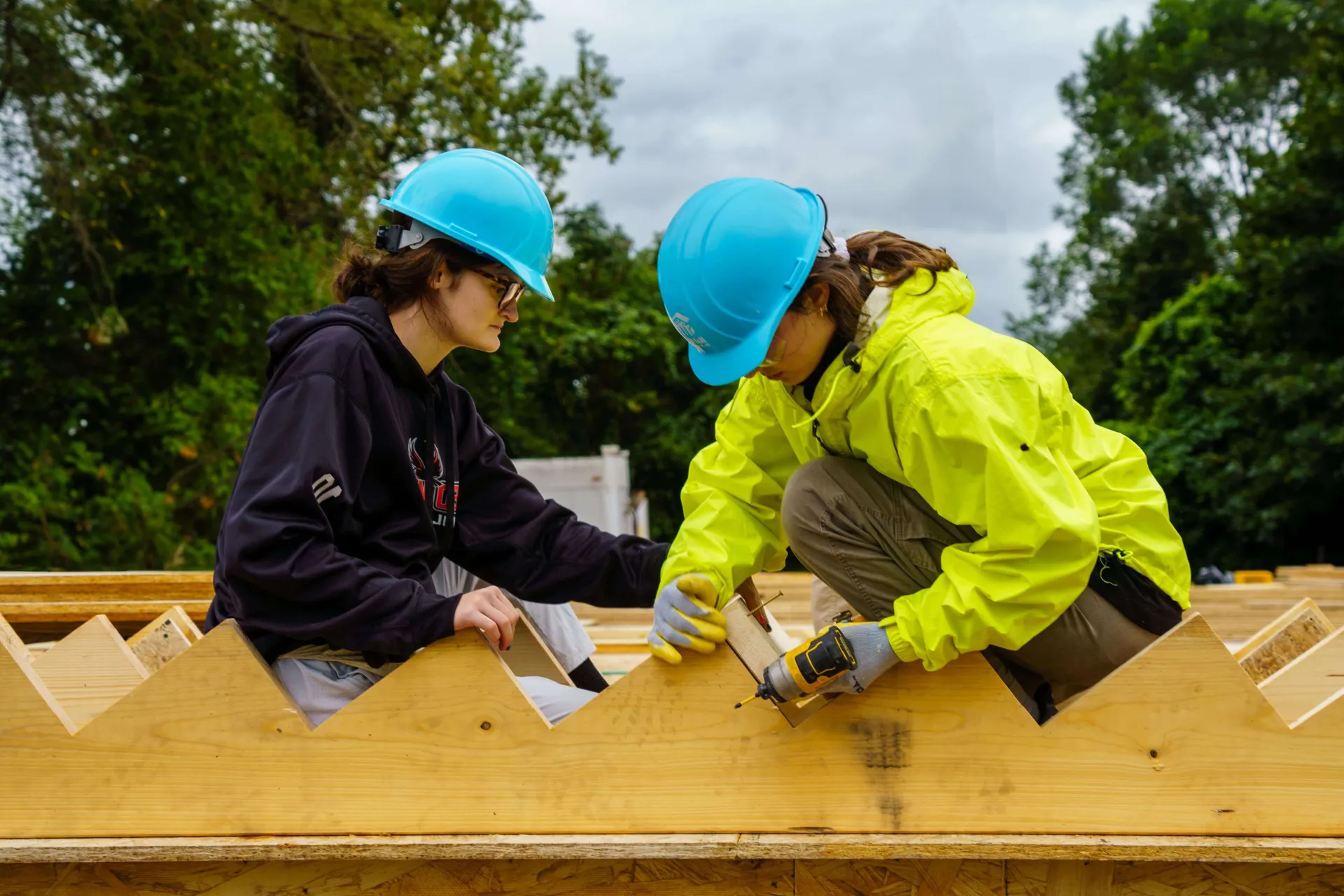 A Trekkie working with wooden planks to build stairs on a service trek trip