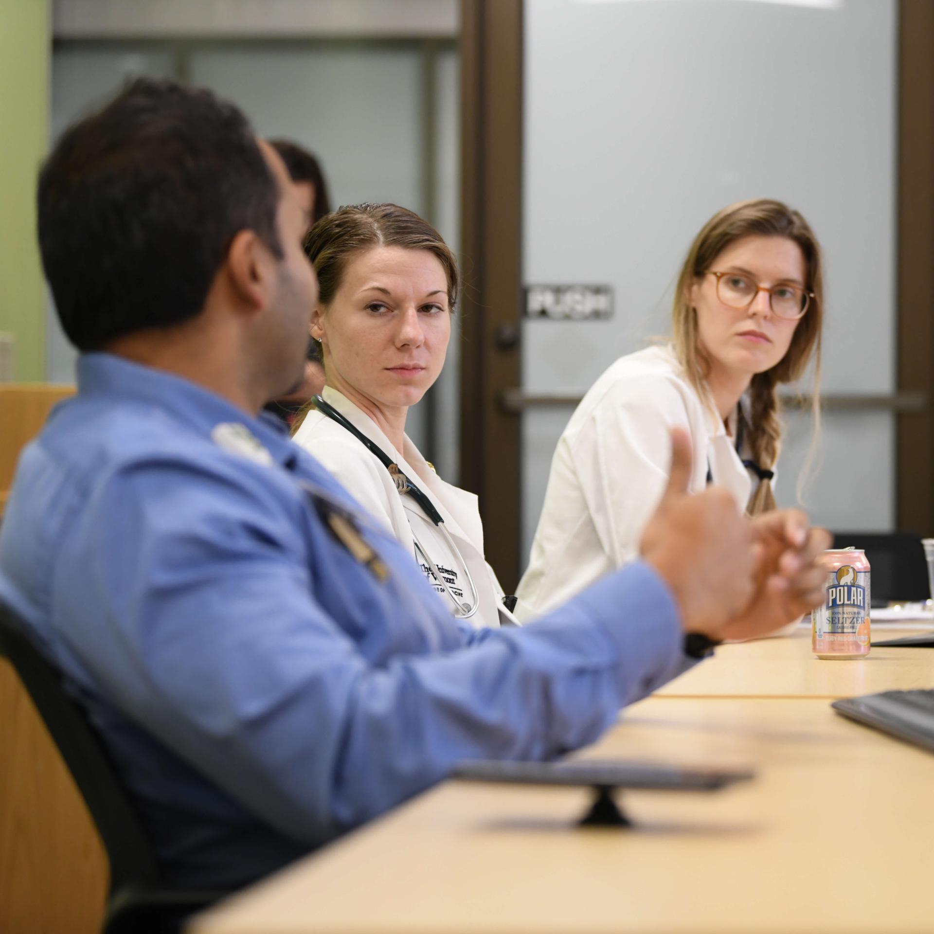 Three physicians at a table discussing pulmonary care.