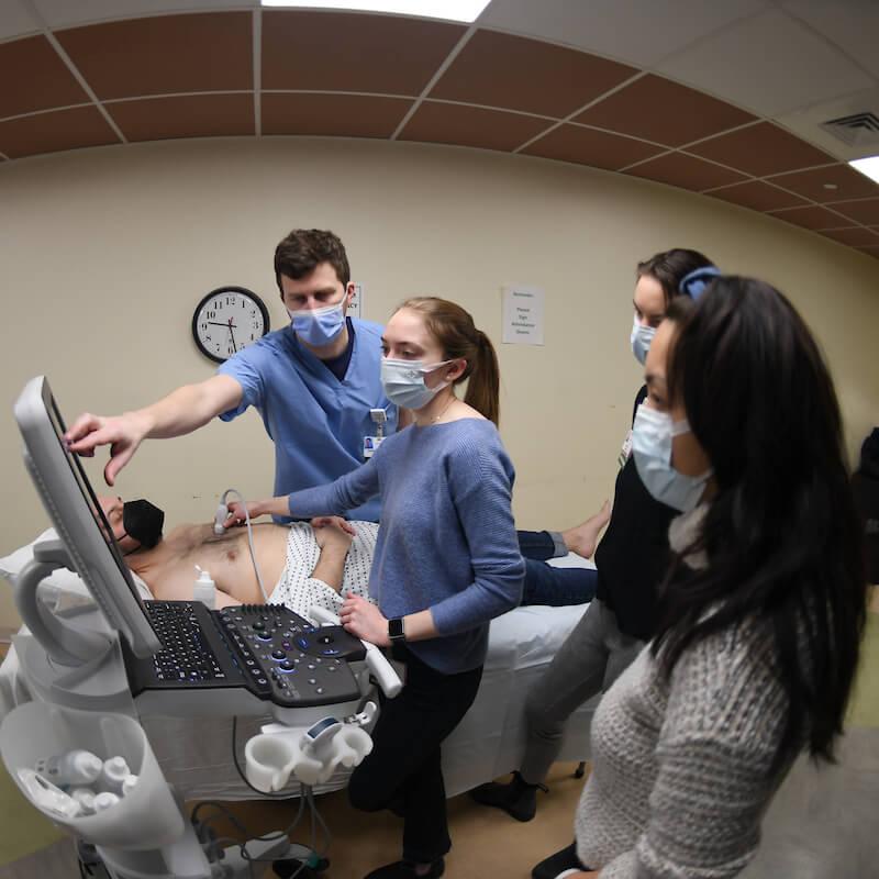 A group of medical staff perform pulmonary tests on a patient.