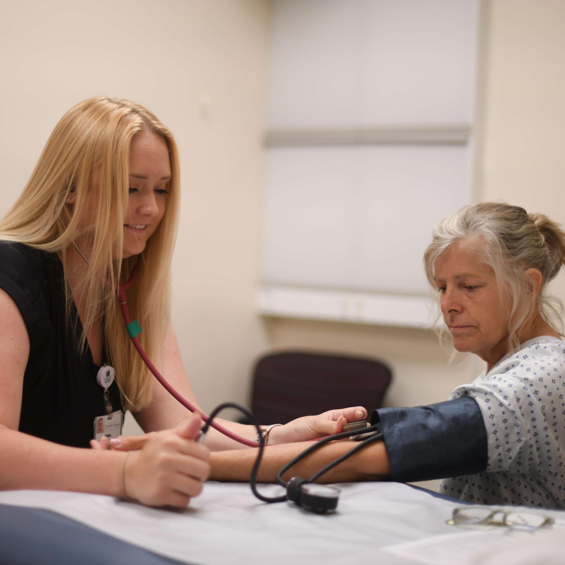 A physician performing a blood pressure test on a patient.