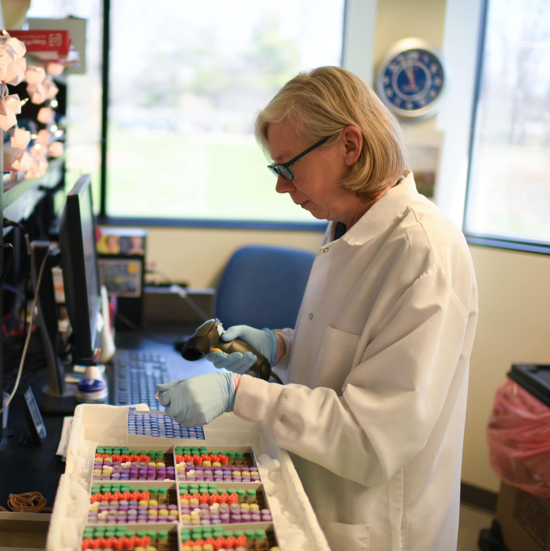A research scientists collecting test tube samples in a lab.