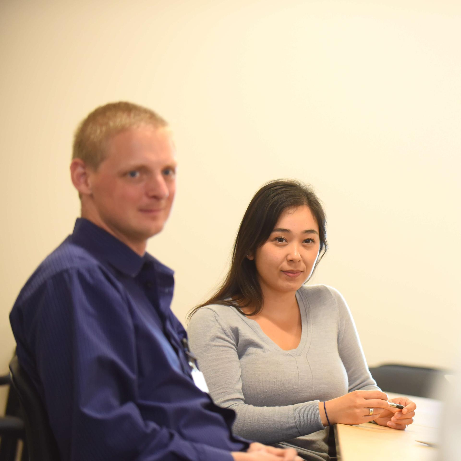 Two residents listen to a guest lecturer.