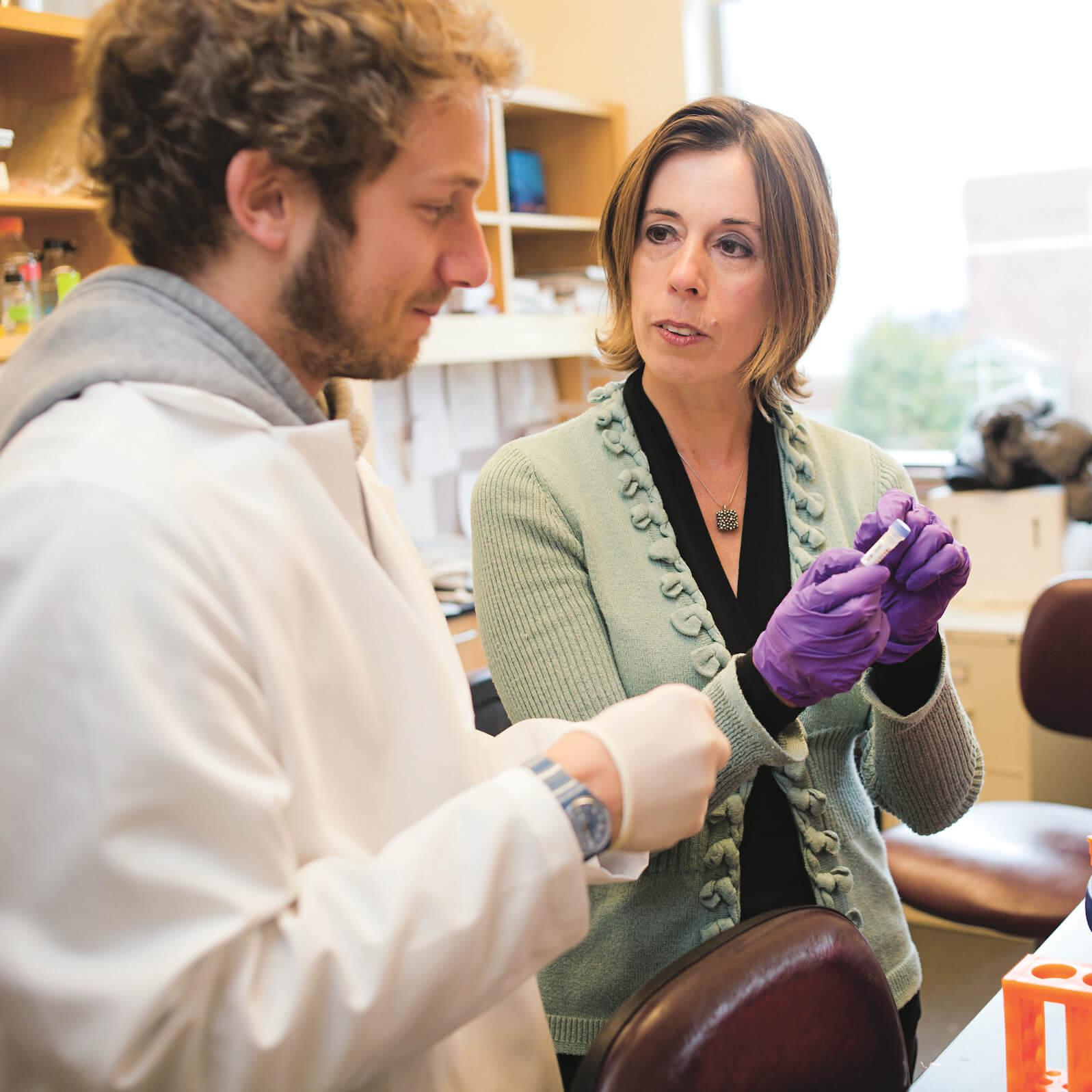 A physician and a student conversing about a lab sample. 