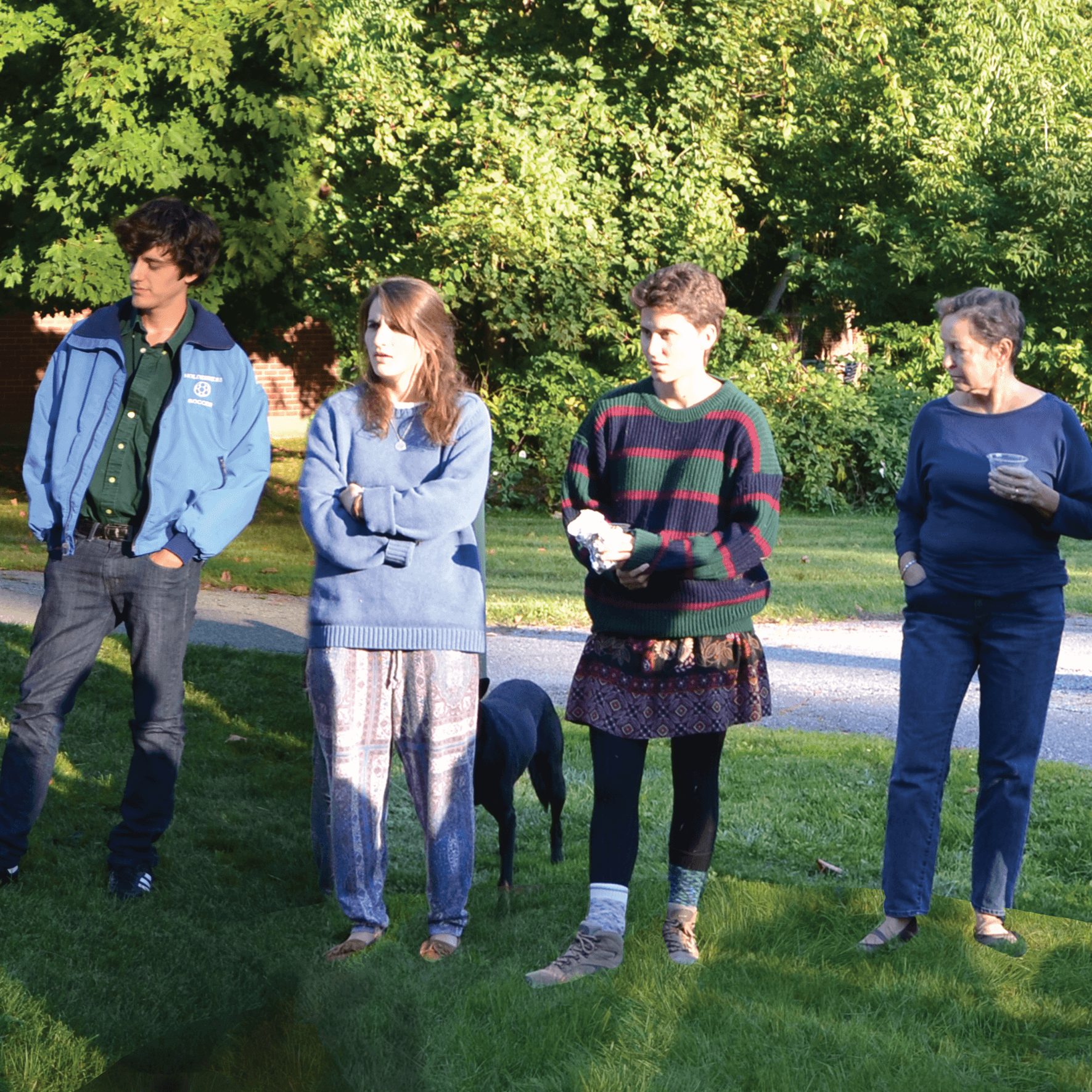 Group of people with a dog standing in a circle.