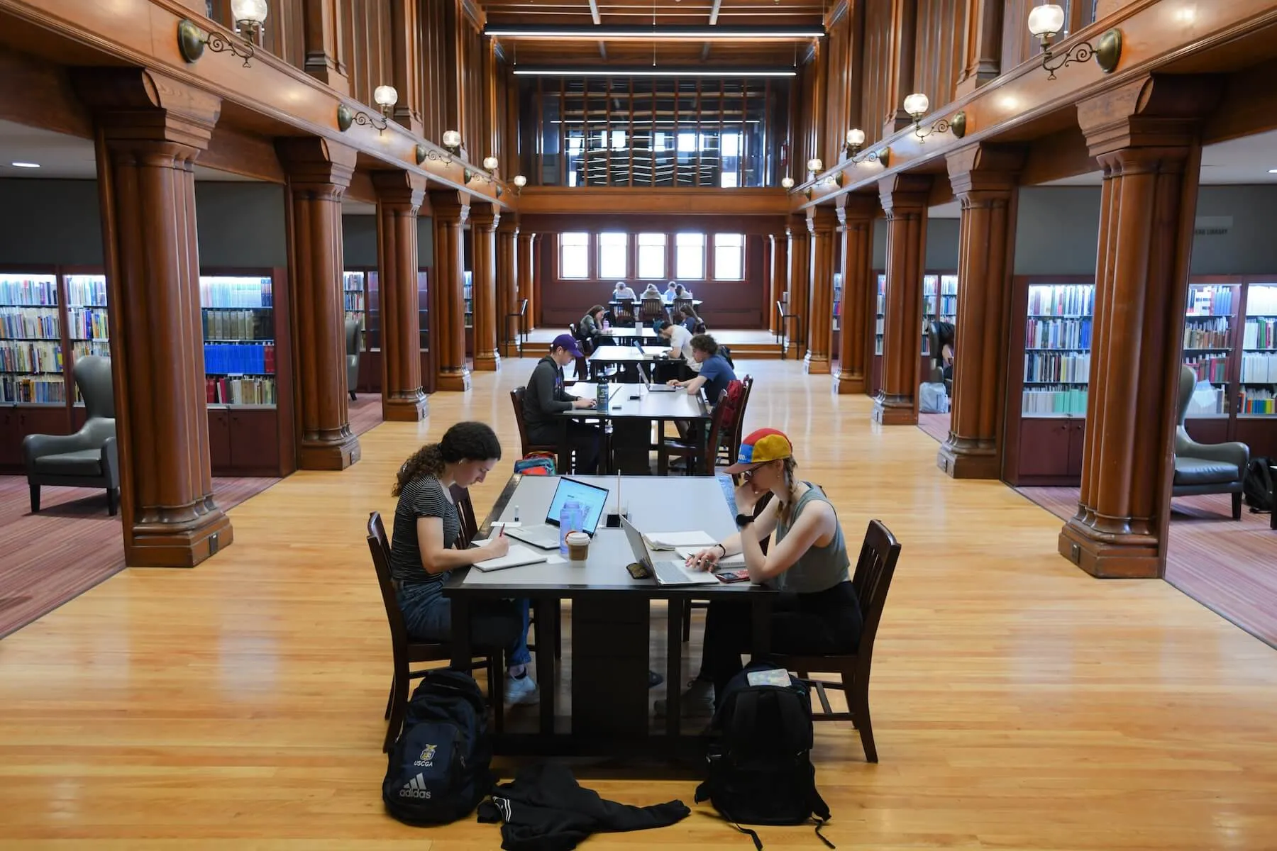 Students study in a grand hall.