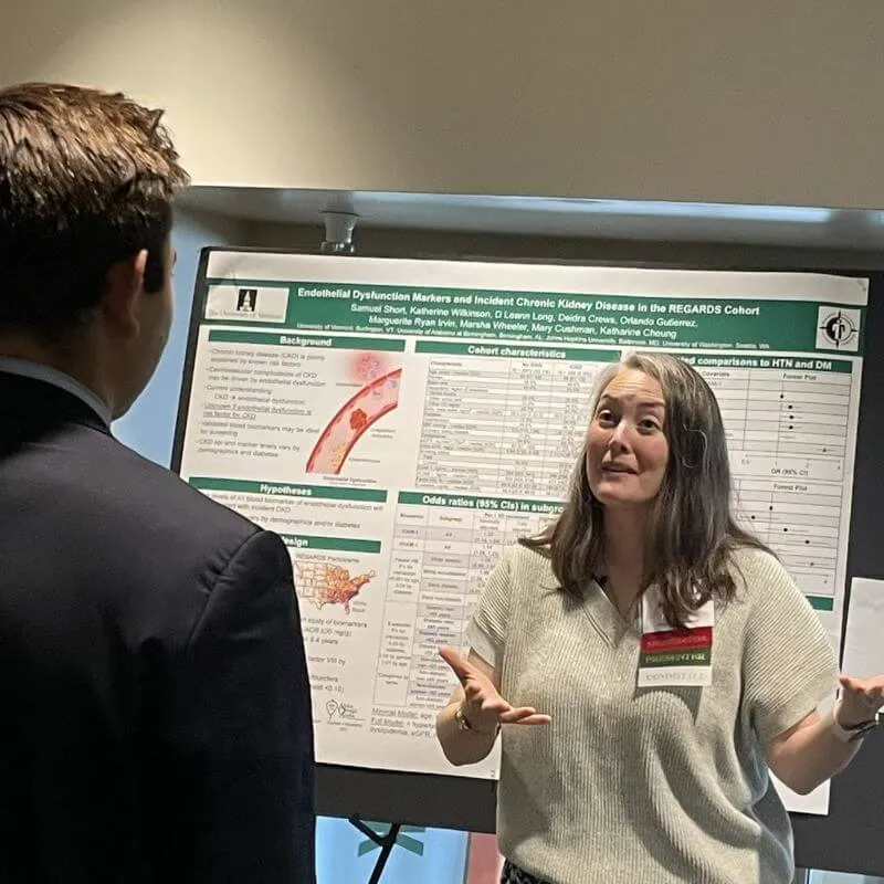 Researcher presenting a scientific poster to another person.