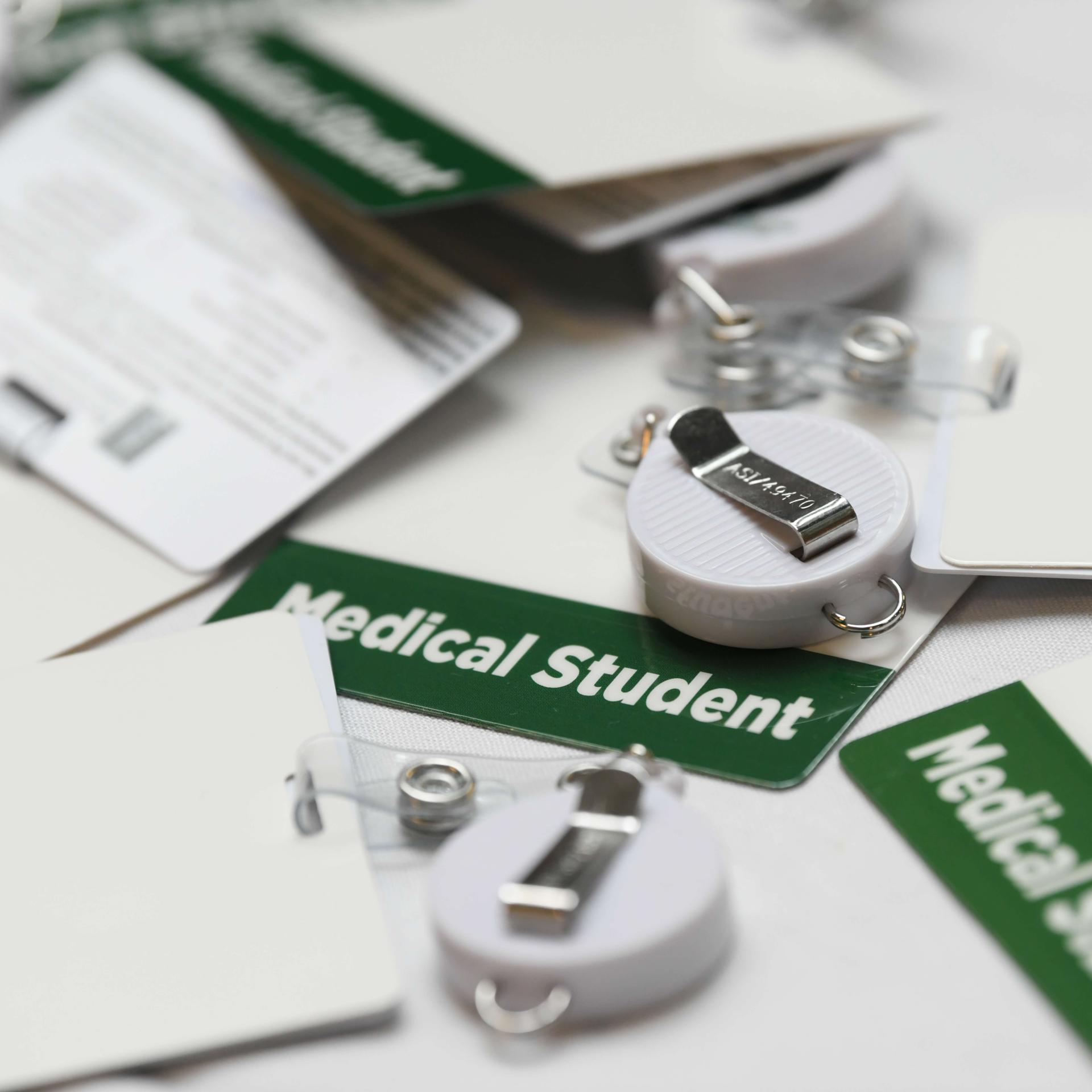A pile of medical student badges on a white background.