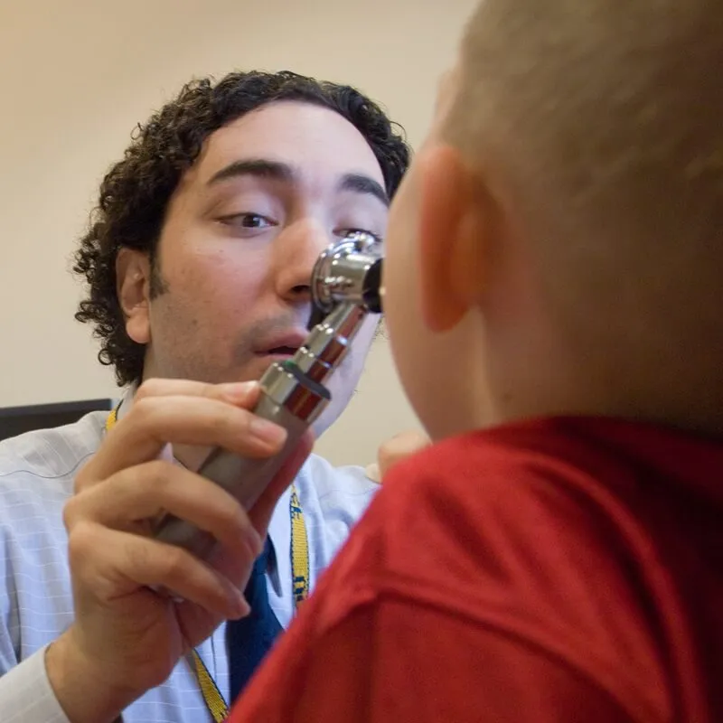 doctor looking into a child's mouth with magnifier