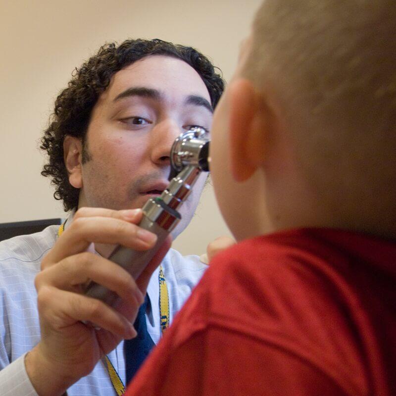 doctor looking into a child's mouth with magnifier