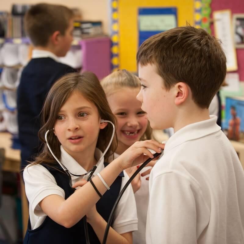 three youngsters play with stethoscope