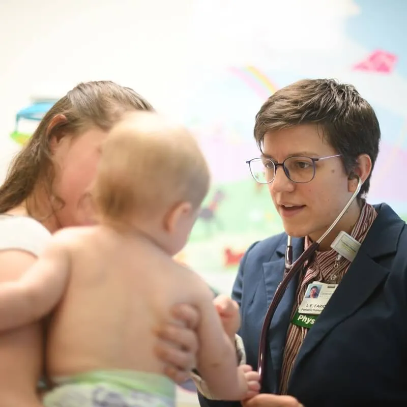 doctor talking to mother holding baby