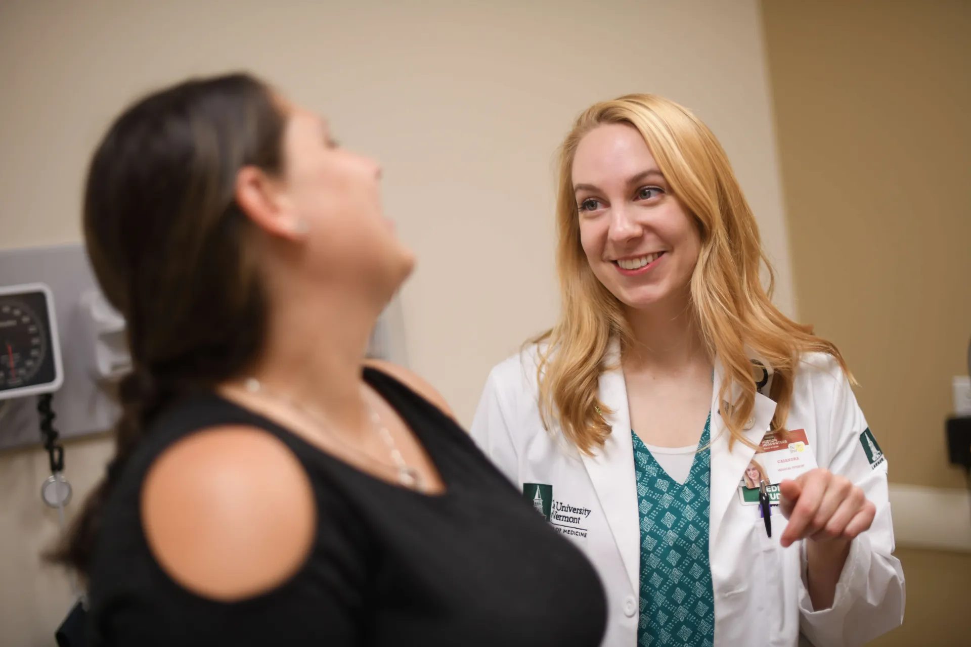 A patient and physician smiling and conversing.