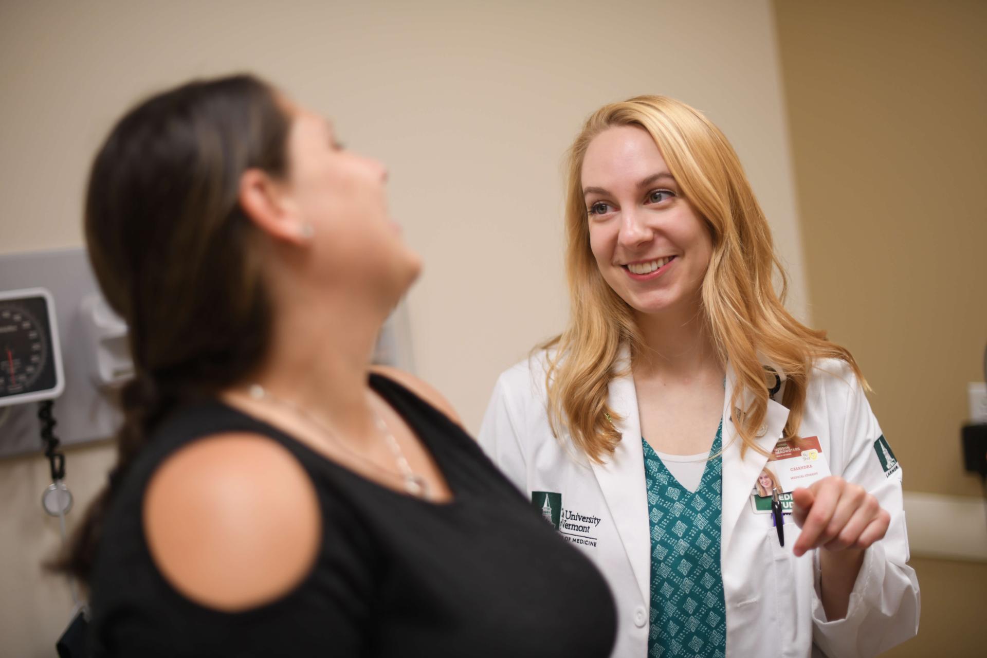 A patient and physician smiling and conversing.
