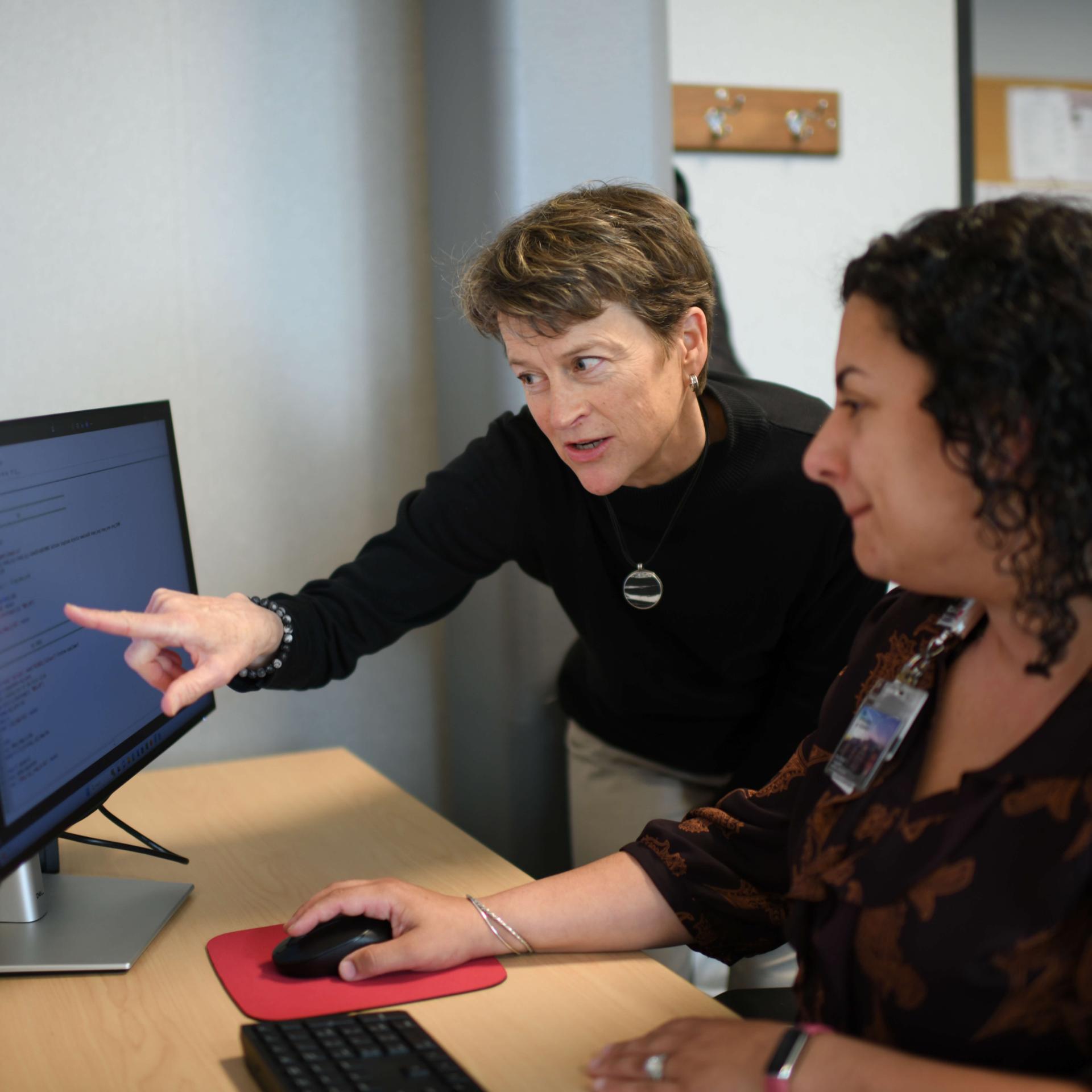 Two healthcare workers discussing patient care.