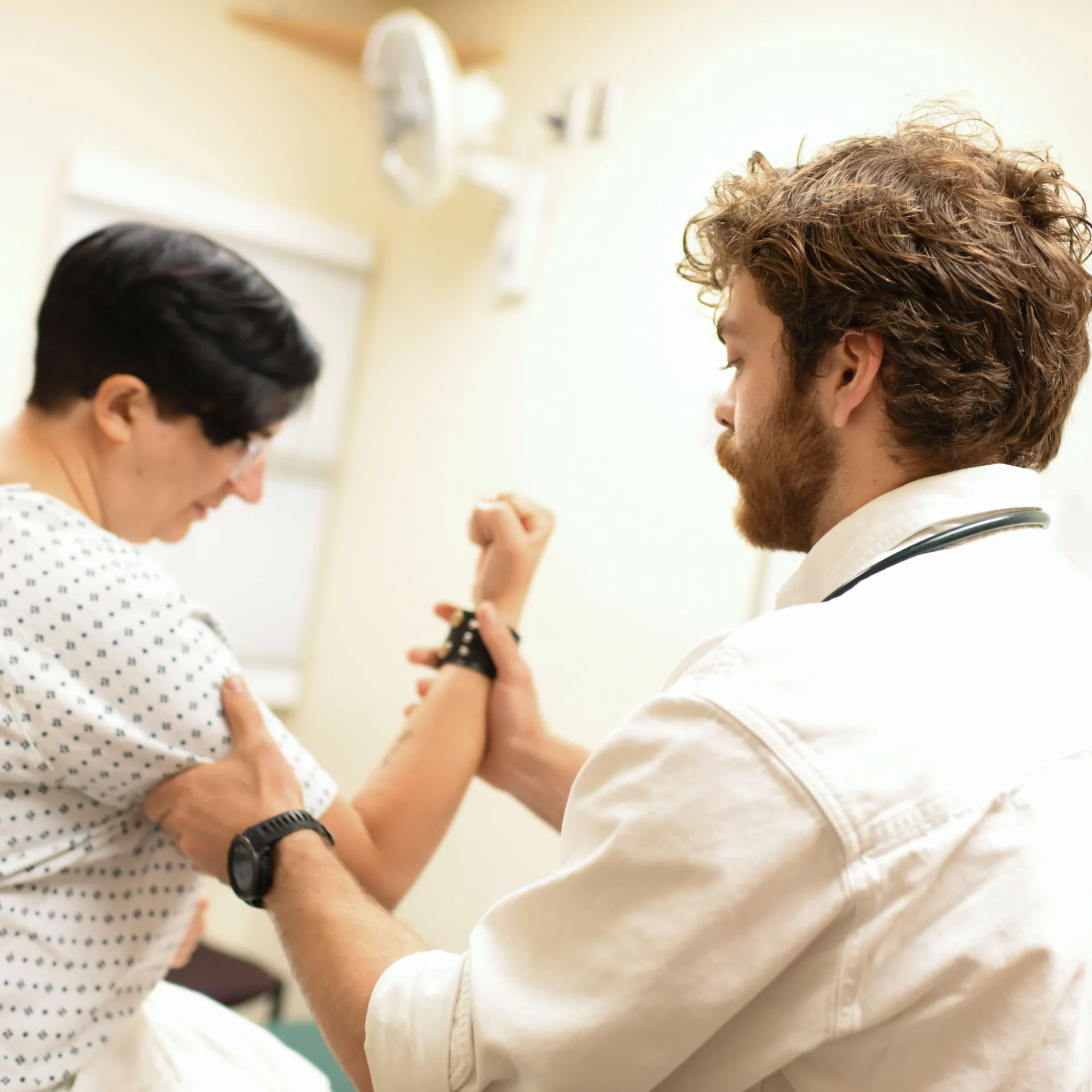A resident checking the joint health of a patient.