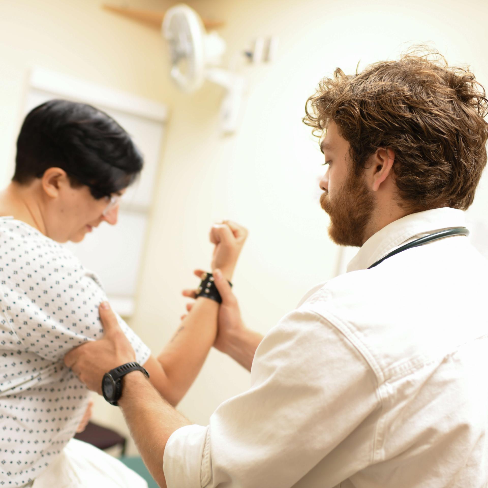 A resident checking the joint health of a patient.