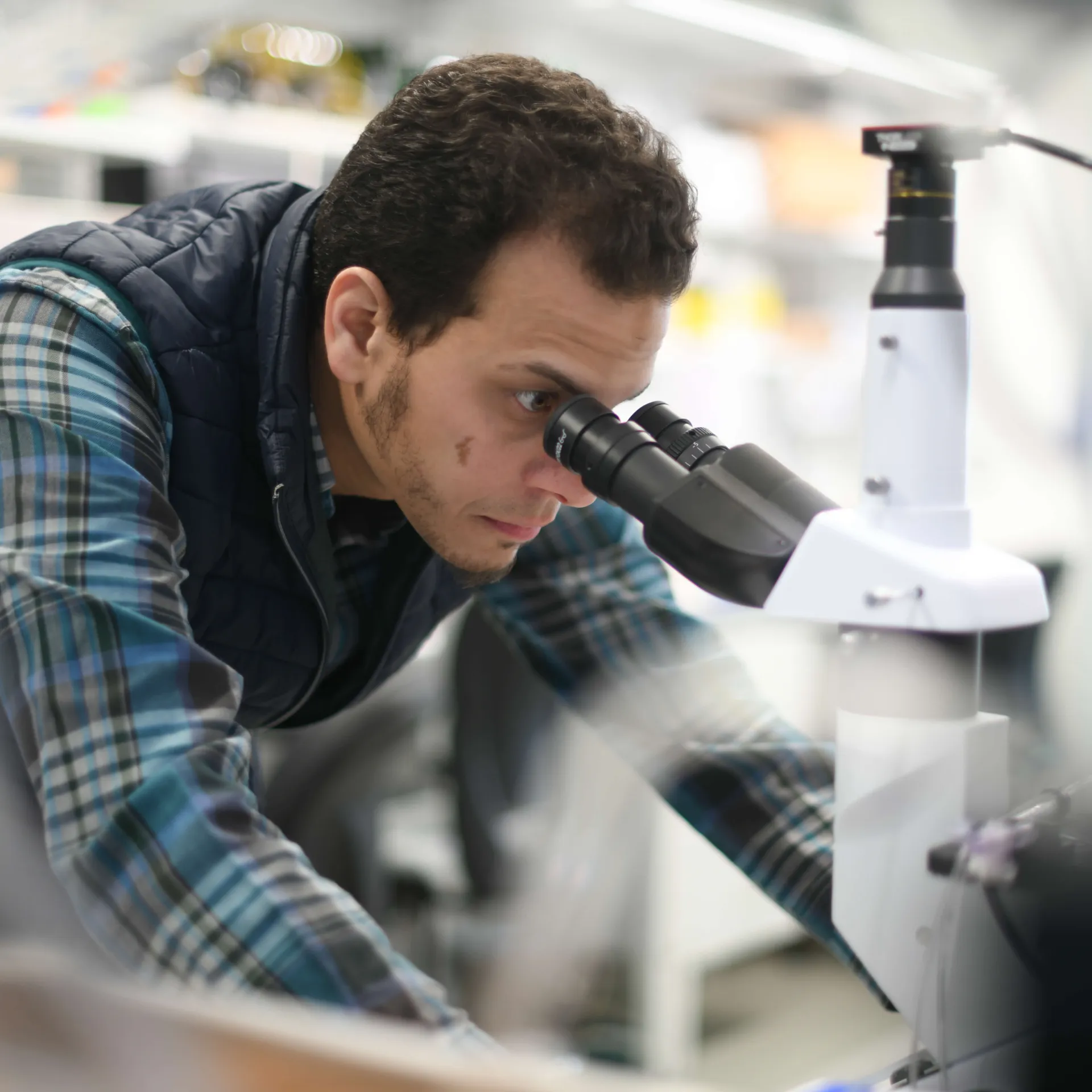 A researcher looking into a microscope.