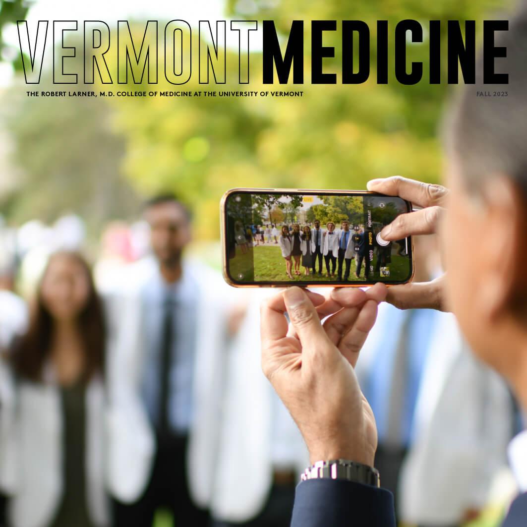 person taking a cell phone photo of med students in new white coats