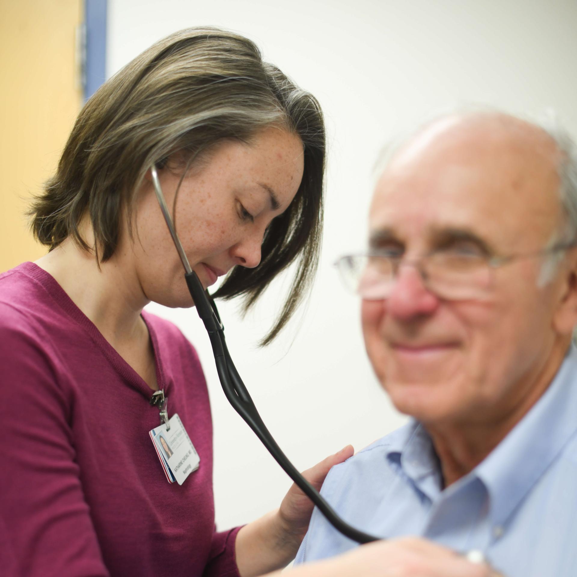 A doctor listening to a patient's heart with a stethoscope.