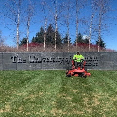 grounds worker sitting on a lawnmower