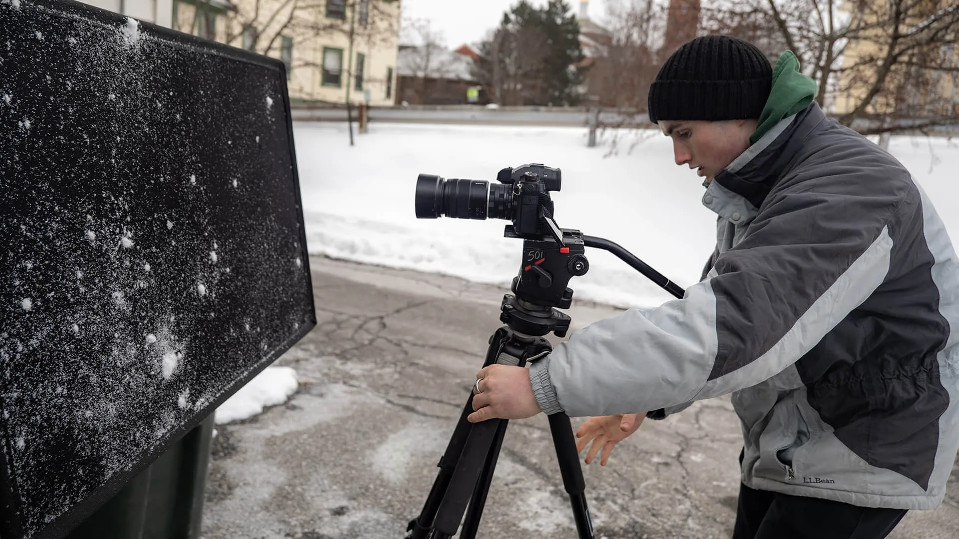 University of Vermont intern for Across the Fence sets up a camera on a tripod