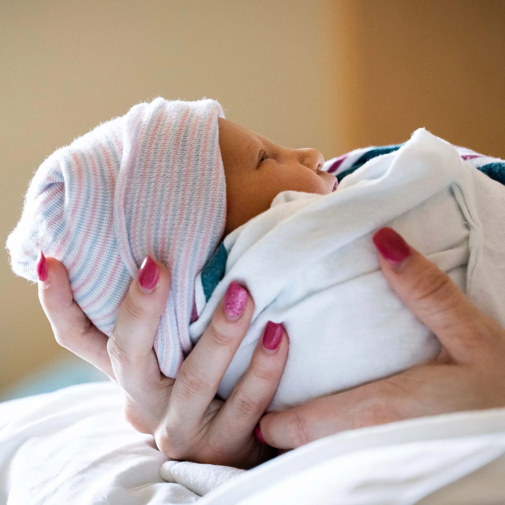 A mother holding a newborn infant.
