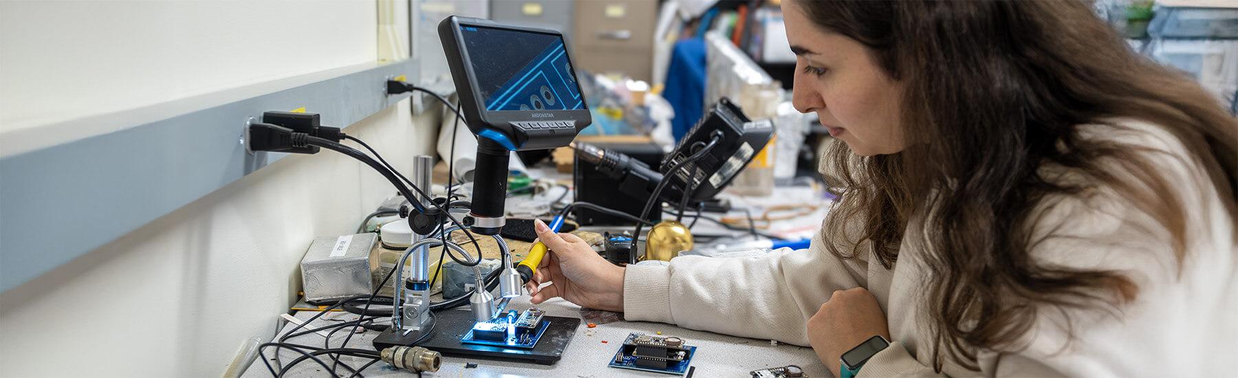 CEMS student soldering a circuit board 