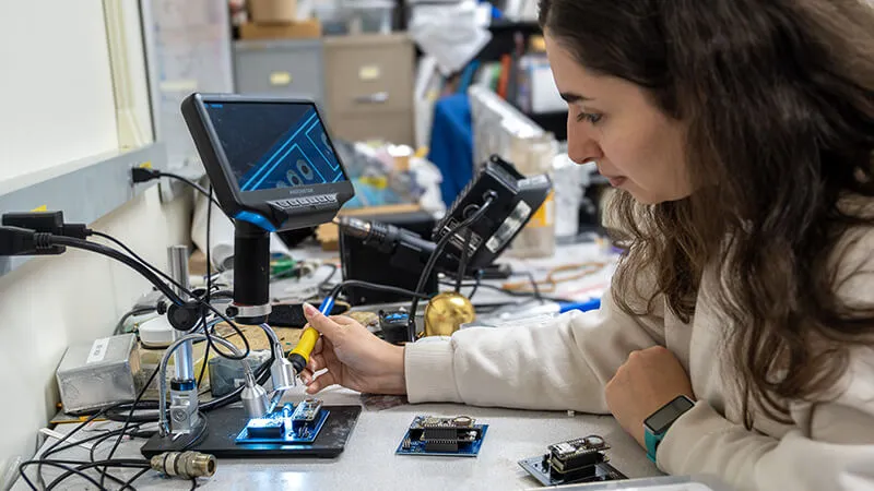CEMS graduate student building a circuit board in an electrical and computer engineering lab