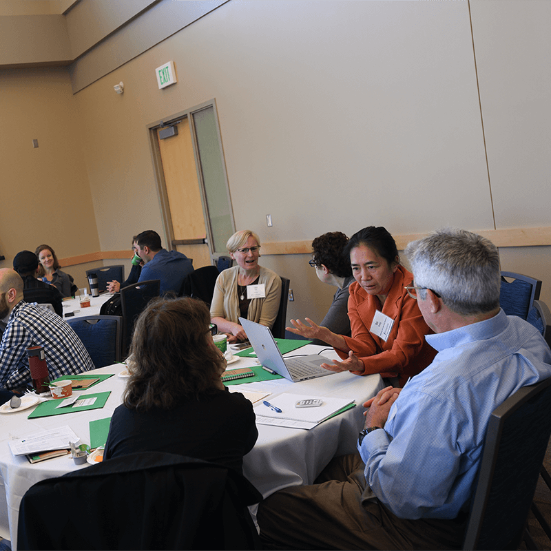A group of people at a table reviewing a paper