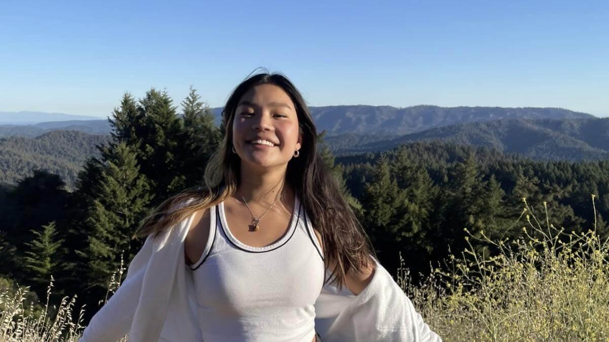 Juliana standing in front of a forested collection of hills.