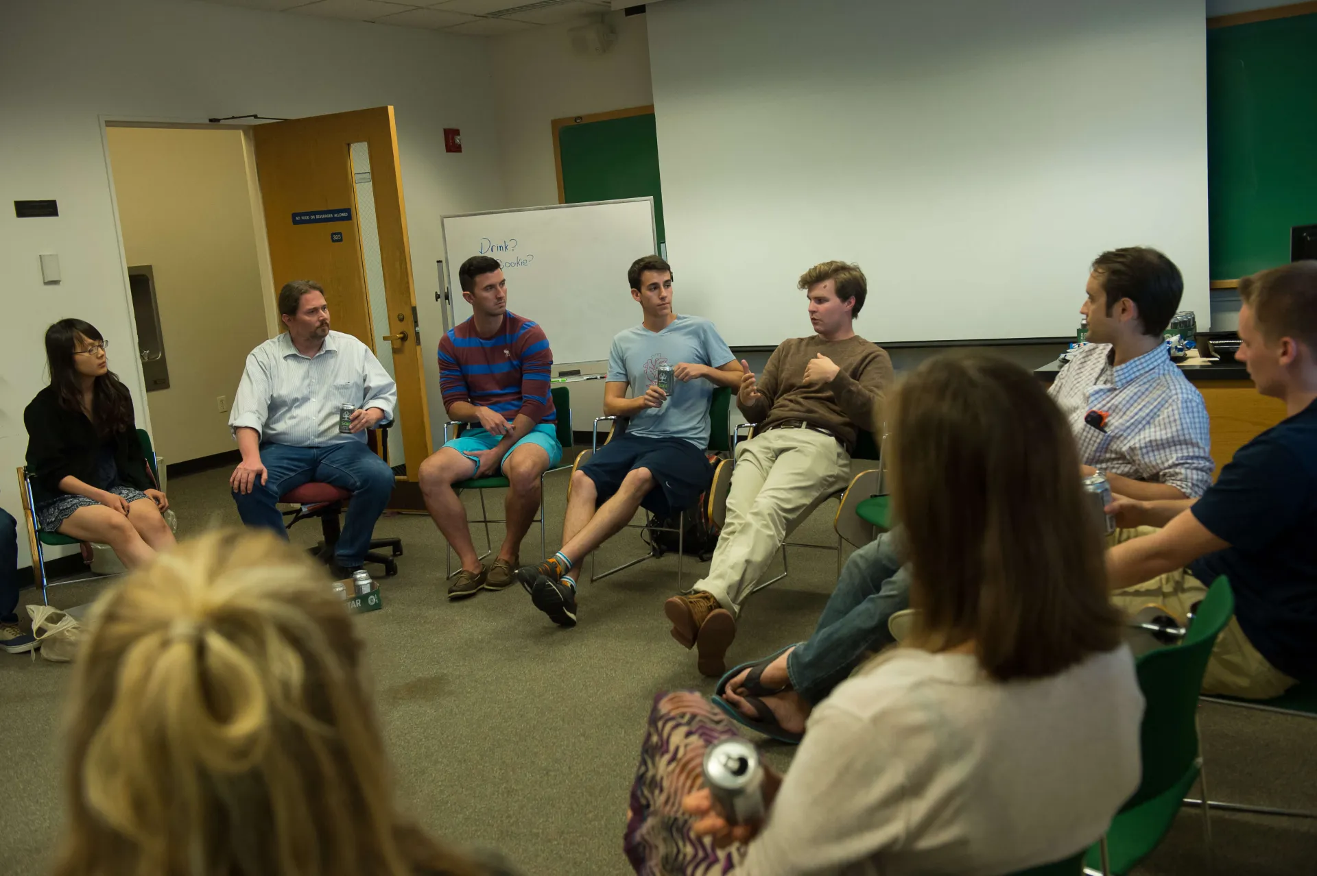 Group of people sitting in a circle in a classroom engaged in conversation