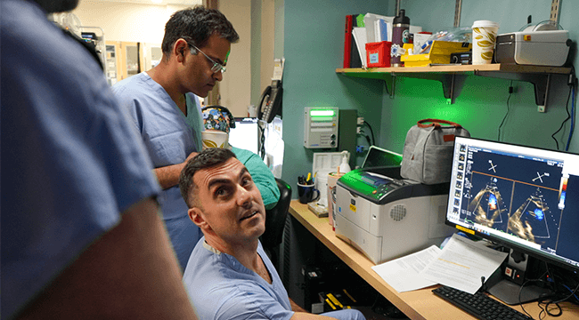three doctors looking at a computer