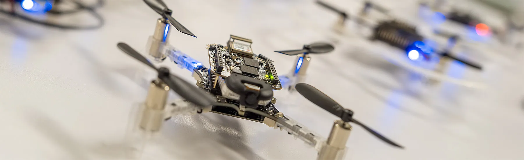 A fleet of small drones ready for take-off in a CEMS autonomy research lab