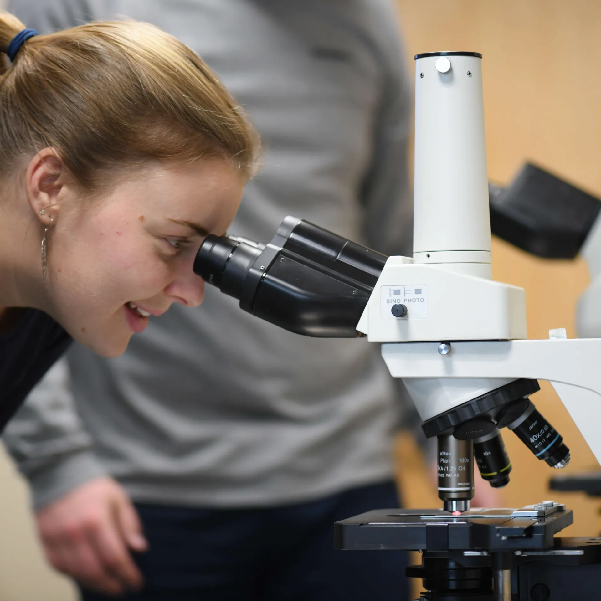 Student looking through microscope 