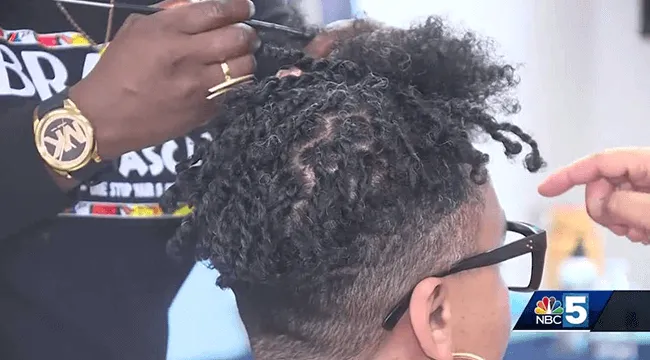 a person styling a Black person's textured hair