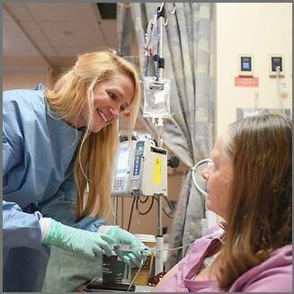 A nurse helps a patient with a chemotherapy infusion