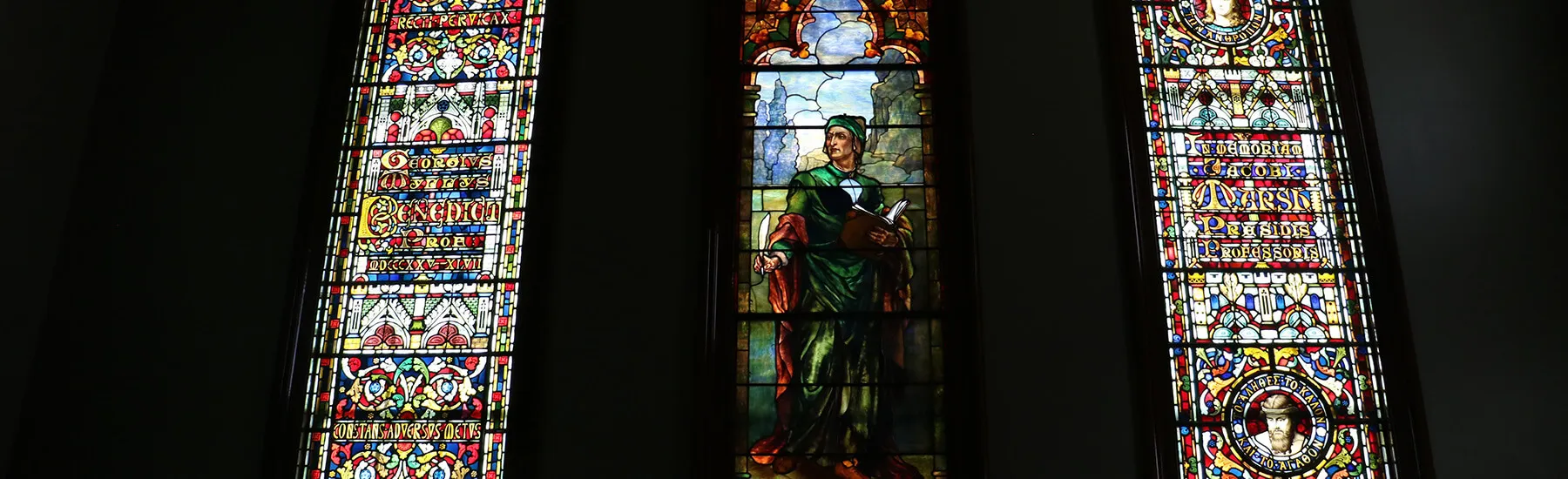 A grand glass window showcasing detailed art, casting colorful reflections in the room